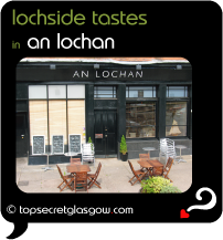 Top Secret Quote Bubble in black, with photo of exterior of An Lochan, with tables & chairs on sunny pavement. Caption: 'lochside tastes'