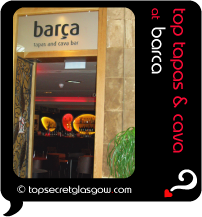 Top Secret Quote Bubble in black, with photo of entranceway of Barca;  glowing interior of chic modern bar with orange and lemon lights. Caption: 'top tapas & cava'