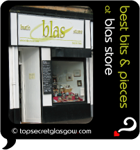 Top Secret Quote Bubble in black, with photo of exterior of Blas Store;  white with black trim, blackboard of specials, window display. Caption: 'best bits & pieces'