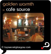 Top Secret Quote Bubble in black, with photo of glowing interior of cafe. Caption: 'golden warmth'