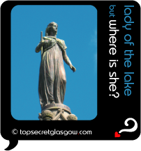 Top Secret Quote Bubble in black, with statue of lady in long gown, bright blue sky.