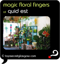 Top Secret Quote Bubble in black, with photo of interior surrounded by plants, flowers and gifts. Caption: 'magic floral fingers'