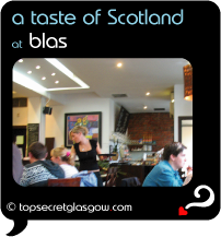 Top Secret Quote Bubble in black, with photo of light bright interior of Blas;  blonde waitress in black serving drinks to group of guests. Caption: 'a taste of Scotland'