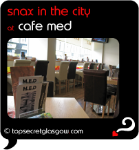 Top Secret Quote Bubble in black, with photo of menus and tables, towards the windows.  Caption: 'snax in the city'