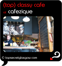 Top Secret Quote Bubble in black, with photo of waiter collecting drinks at bar, photo of Zique behind, blackboard to right. Caption: 'top classy cafe'