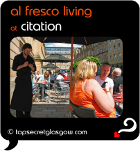 Top Secret Quote Bubble in black, with photo of waiter tending to terrace tables in sunshine. Caption: 'al fresco living'