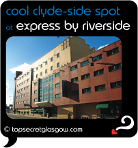 Top Secret Glasgow lozenge showing building shining is sun from across empty street. Caption: cool clyde-side spot