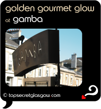 Top Secret Quote Bubble in black, with photo of the Gamba signage against fuzzy backdrop of blond sandstone townhouses bathed in golden light against blue washed sky.  Caption: 'golden gourmet glow'
