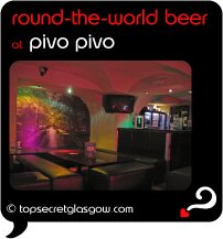 Top Secret Quote Bubble in black, with photo of bar area with funky red and orange lighting. Caption: 'round-the-world beer'